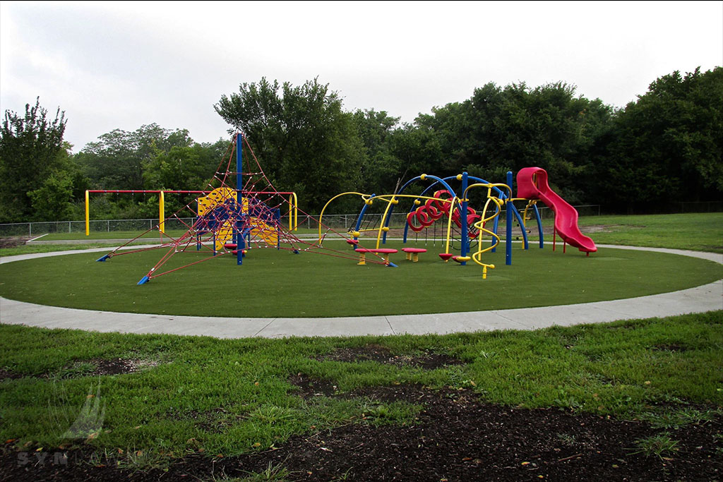 after image of hazel grove elementary playground with a red slide on top of artificial grass