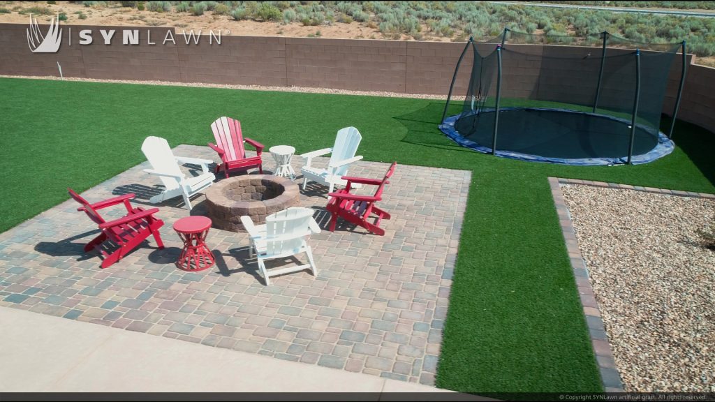 Backyard with fire pit and trampoline with artificial grass surfacing