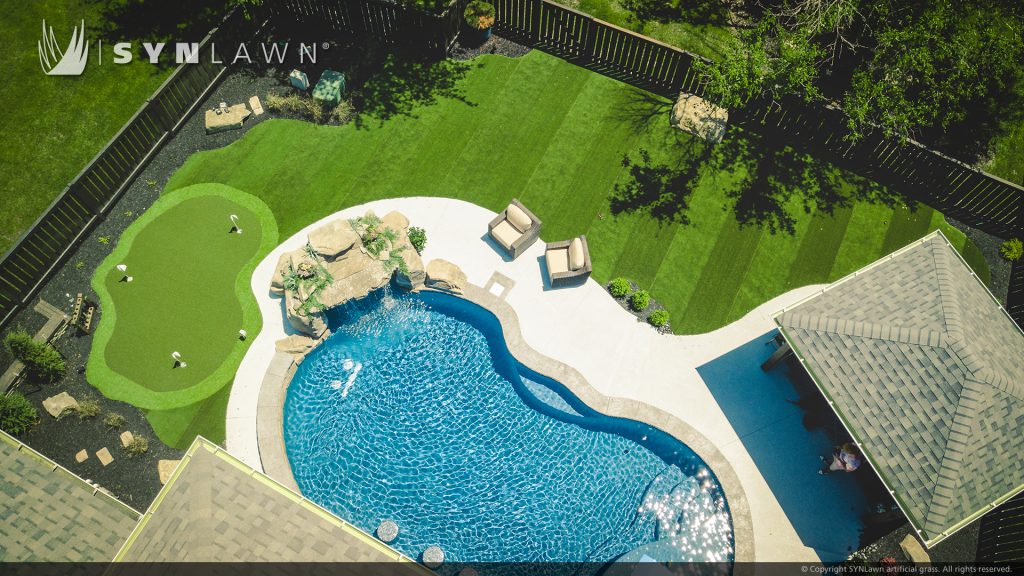 image of residential backyard with striped artificial grass and putting green