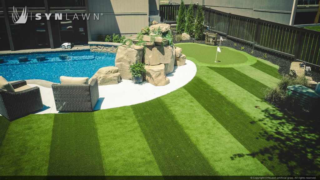 image of residential backyard with striped artificial grass and putting green