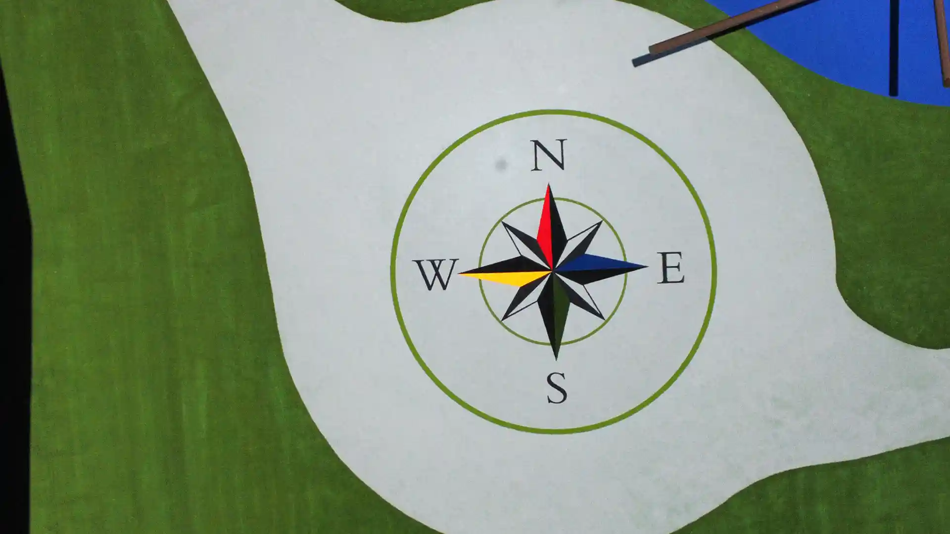 Custom logo fabricated using multiple colors of artificial playground grass by SYNLawn at Texas school playground image of custom logo fabricated from multiple colors of artificial grass by SYNLawn at Texas school playground