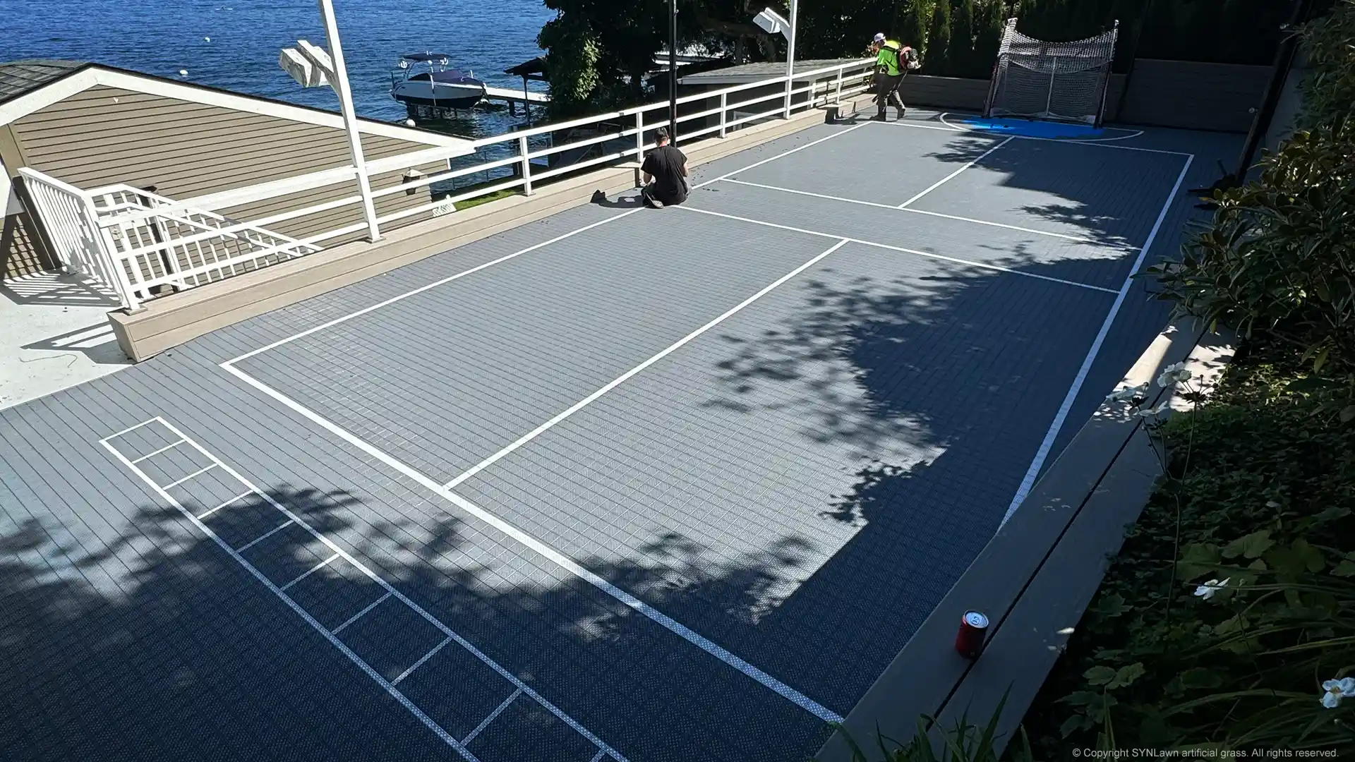 The installation crew from SYNLawn Seattle installing the SYNCourt Sport Tile Court System for Basketball Tennis and more image of syncourt sport tile court system by synlawn being installed in Seattle Washington